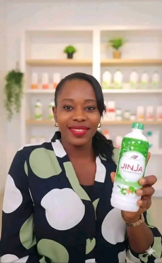 Jinja Herbal distributor holding a bottle of Jinja Herbal Extract